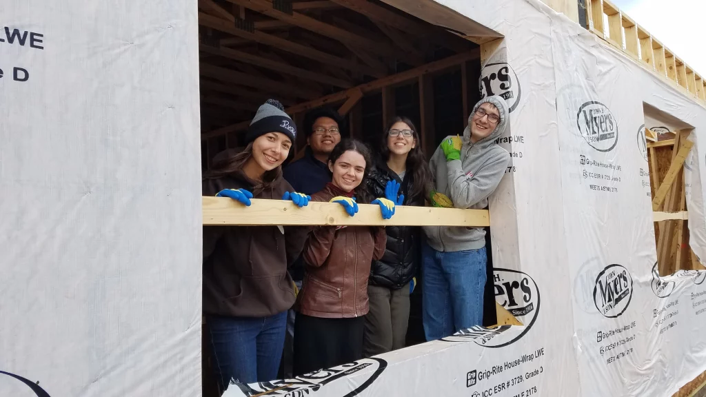 Students building a house together as part of a service project